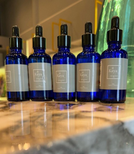 A row of Kaya bottles photographed on a marble counter in a showroom
