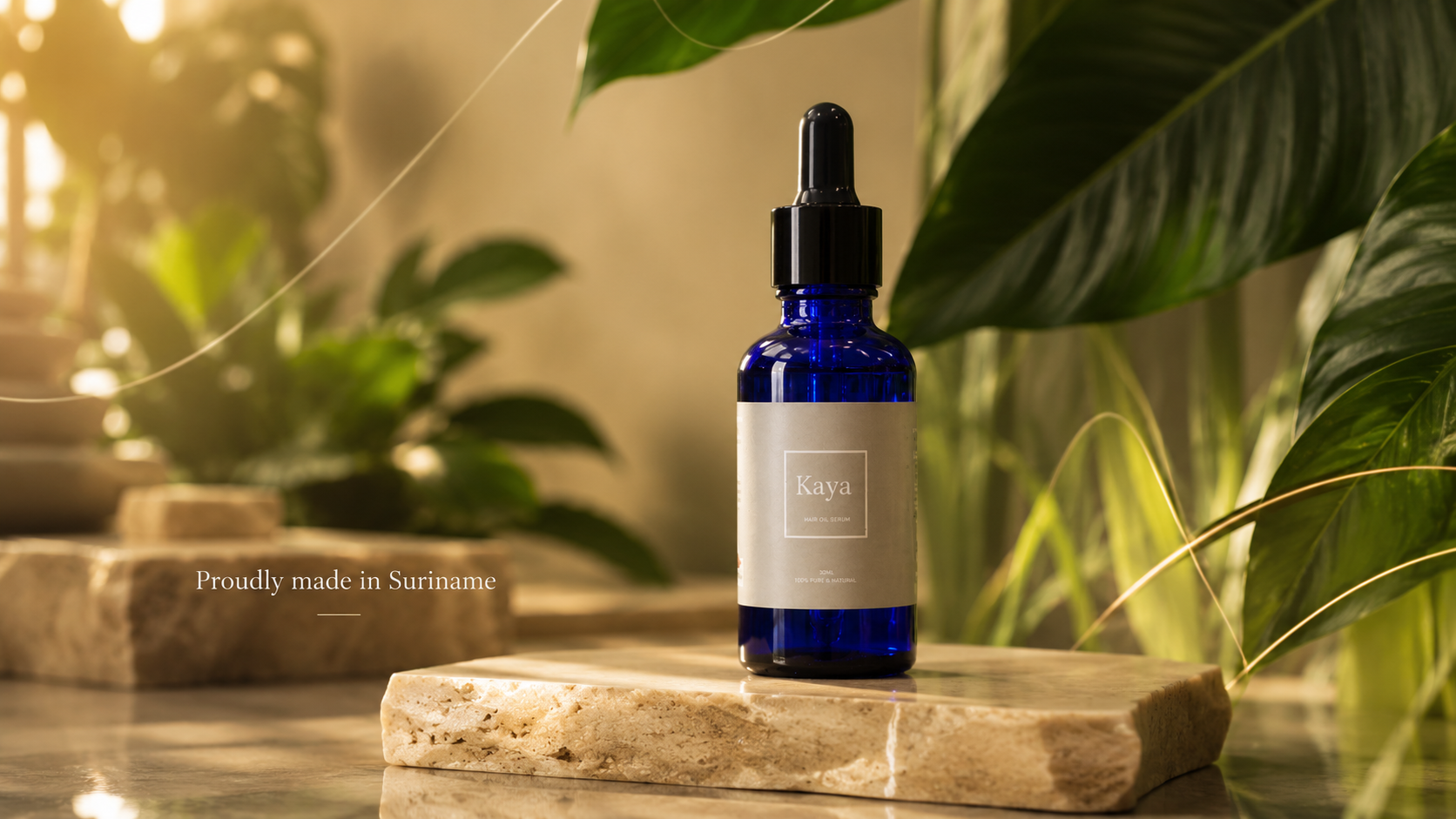 Kaya hair oil bottle on stone with tropical leaves and brand origin message